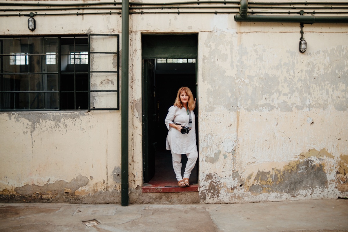 A figure framed in a doorway of a weathered gallery building