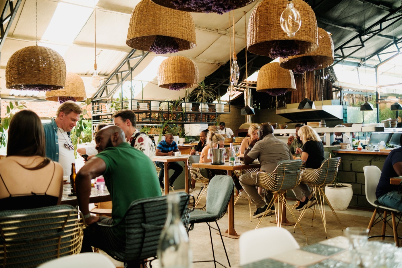A full dining room at Cultiva Kenya beneath woven pendant lamps