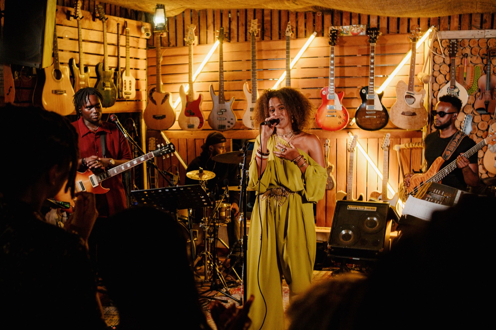 Geco Cafe — a singer and her band beneath a wall of guitars