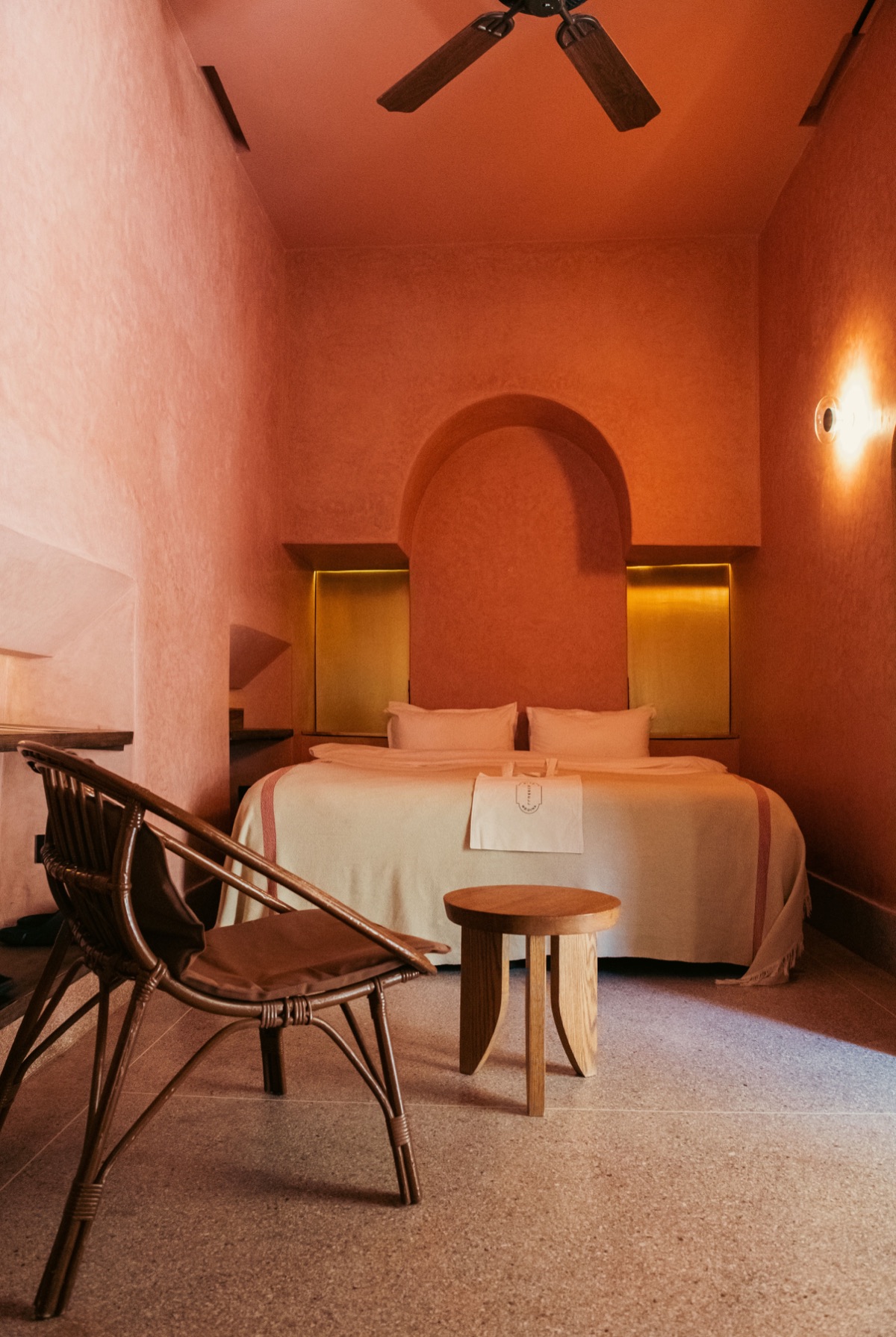 Guest room in ochre tadelakt with arched alcove and brass details